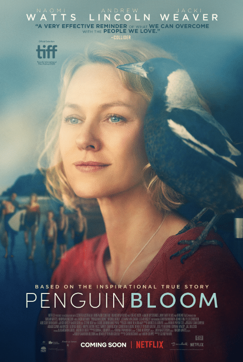 A woman with blonde hair gazes thoughtfully as a magpie perches on her shoulder. Behind her, a blurred family walks along a beach. Text reads: Penguin Bloom, one of our Pop Culture Picks starring Naomi Watts, coming soon to Netflix.
